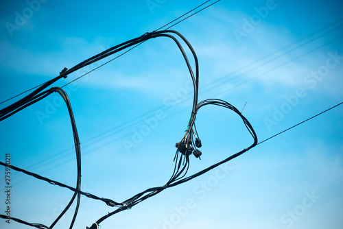 Intersecting connect wires against a blue sky