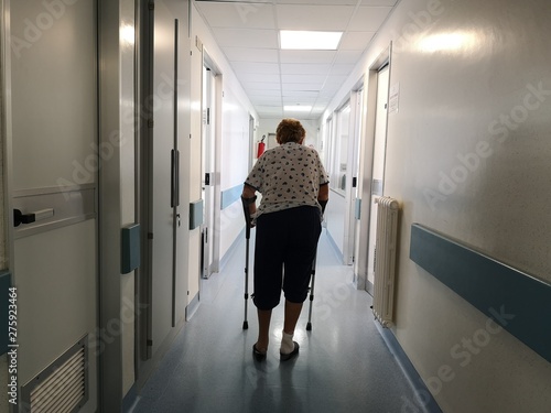 woman with crutches in hospital corridor
