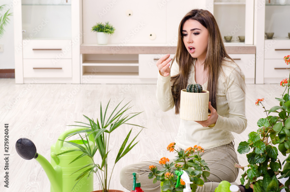Young female gardener with plants indoors Young female gardener with plants indoors