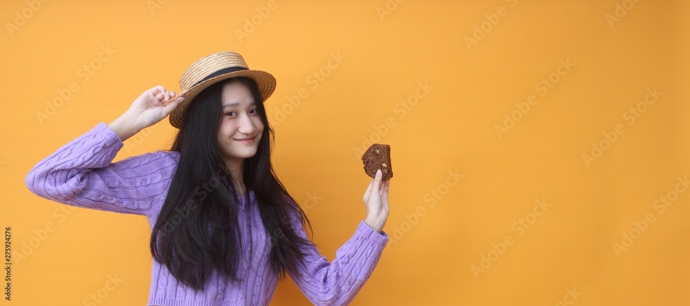 Image of beautiful woman isolated over yellow wall background holding cake. Image of beautiful woman isolated over yellow wall background holding cake.