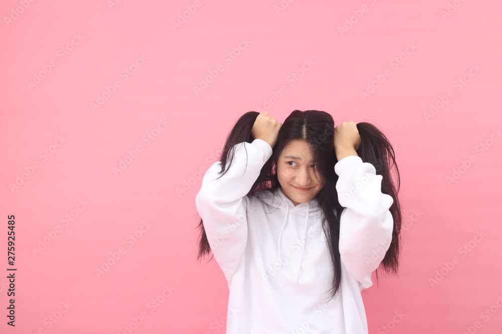 Isolated shot of pretty  Beautiful Asian models over pink  background for advertising  concept , wears casual outfit, being entertained by friend during party