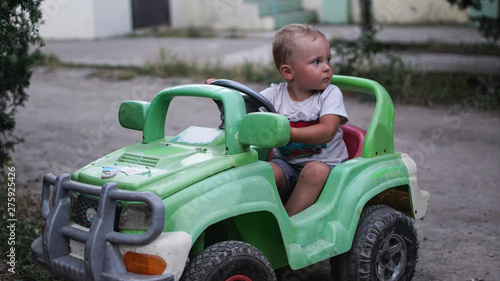 Little preschool boy driving big toy car and having fun, outdoors. © www.akolosov.art 