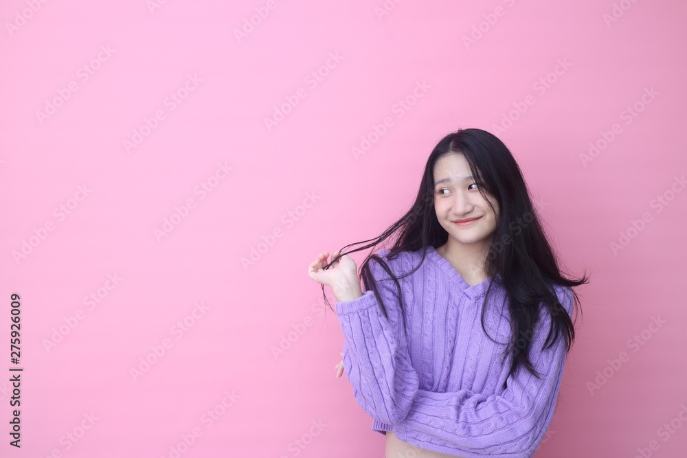 Isolated shot of pretty Beautiful Asian models over pink background for advertising concept , wears casual outfit, being entertained by friend during party Isolated shot of pretty Beautiful Asian models over pink background for advertising concept , wears casual outfit, being entertained by friend during party