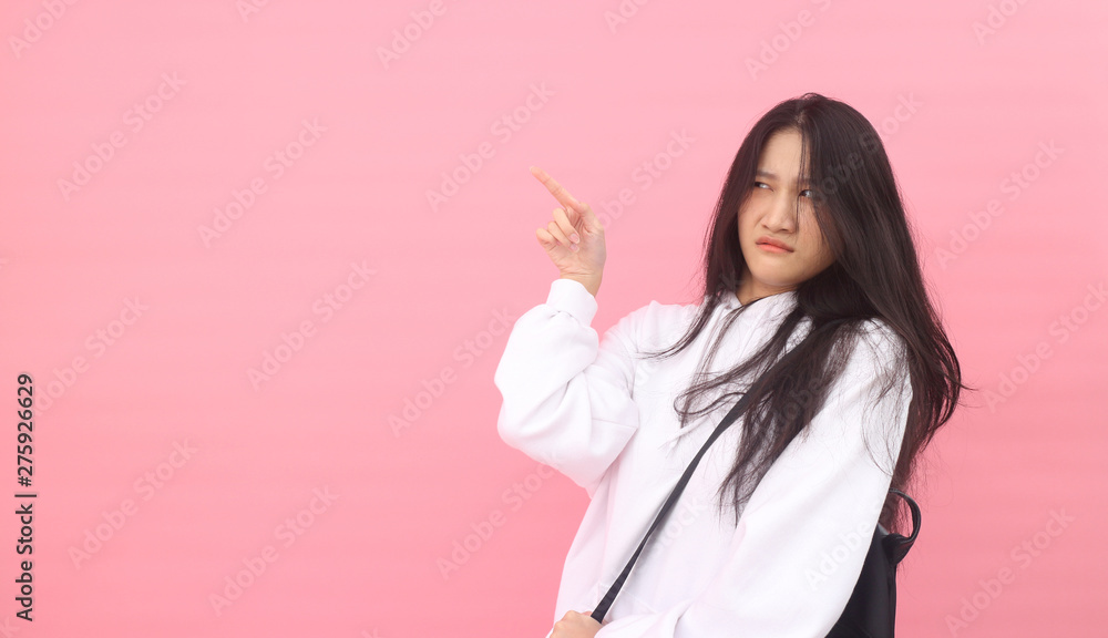 Isolated shot of pretty Beautiful Asian models over pink background for advertising concept , wears casual outfit, being entertained by friend during party Isolated shot of pretty Beautiful Asian models over pink background for advertising concept , wears casual outfit, being entertained by friend during party
