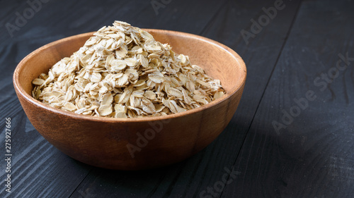 oatmeal in a wooden bowl on a black wooden table