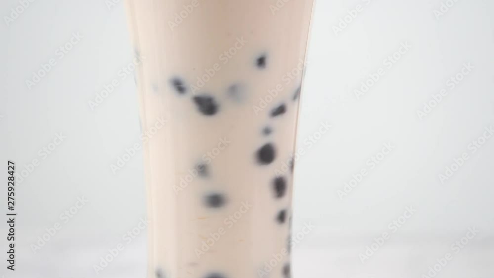 Stirring tasty taiwanese popular drink tapioca pearl bubble milk tea in glass cup on bright marble table white tray, homemade concept. 4K shot video Stirring tasty taiwanese popular drink tapioca pearl bubble milk tea in glass cup on bright marble table white tray, homemade concept. 4K shot video