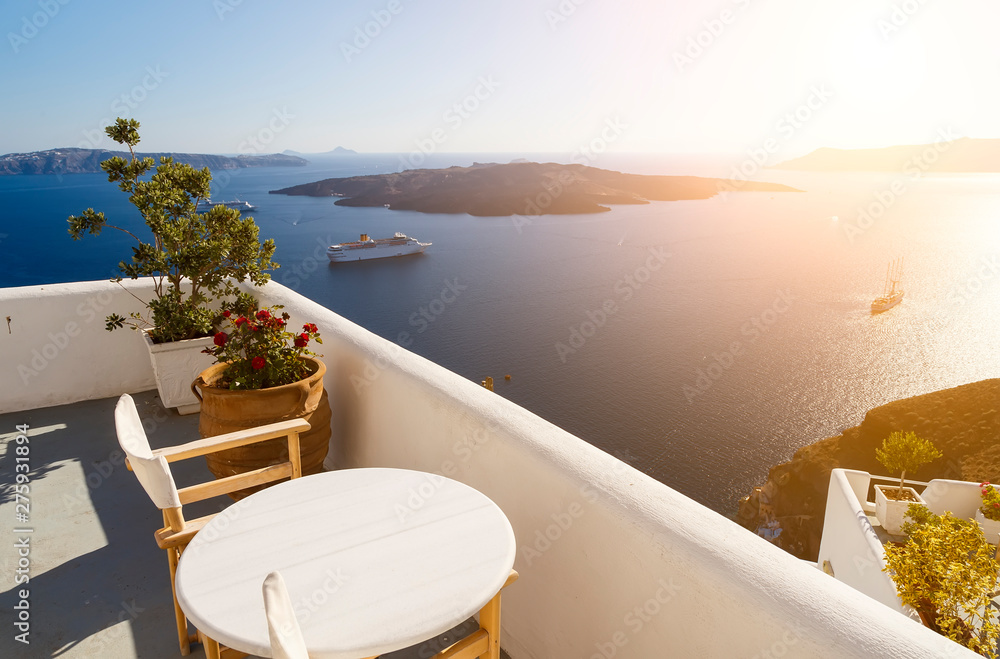Beautiful sunset at Santorini island, Greece. Two chairs on terrace with sea view