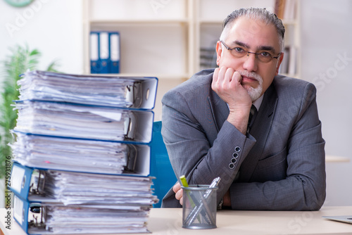 Aged male employee unhappy with excessive work 