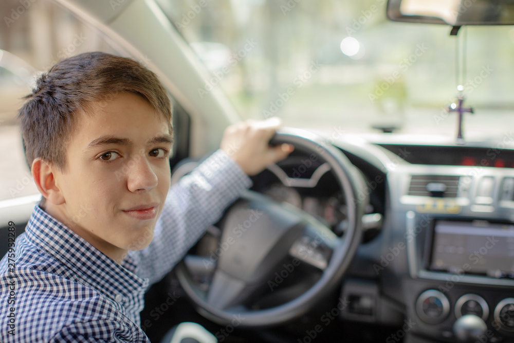 Young boy driving a car. Teen behind the wheel of a car. teenager stole a car Young boy driving a car. Teen behind the wheel of a car. teenager stole a car