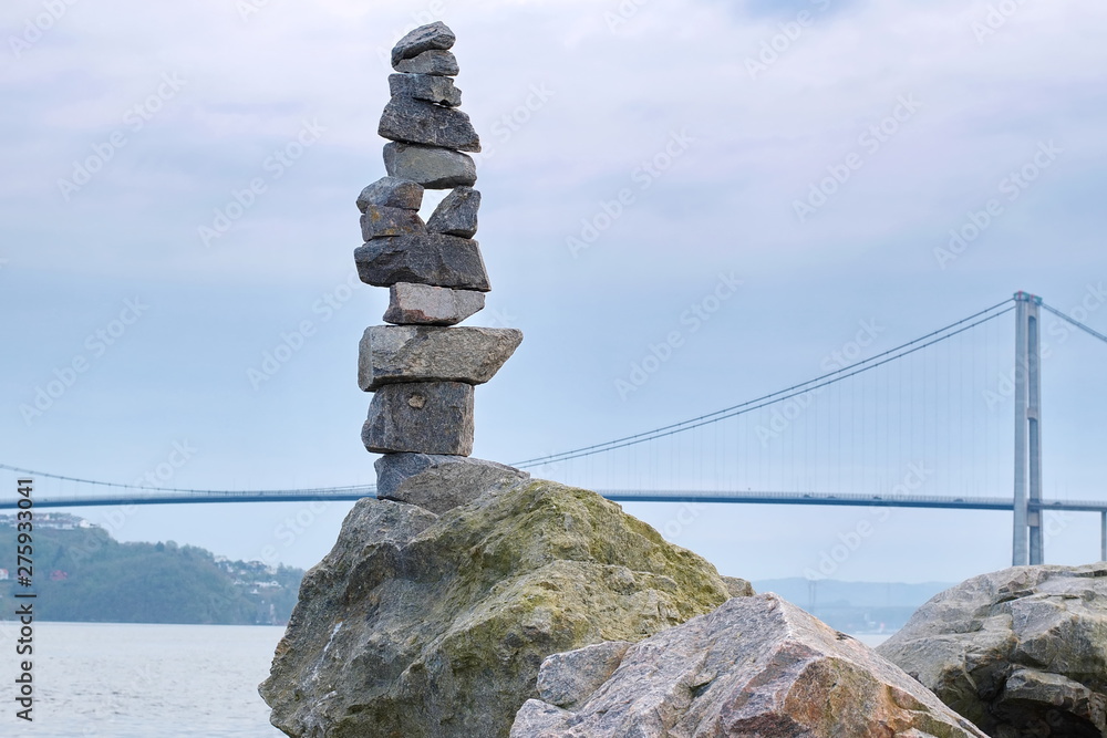 Pyramid of stones on the background of the fjord and the bridge in Norway Pyramid of stones on the background of the fjord and the bridge in Norway