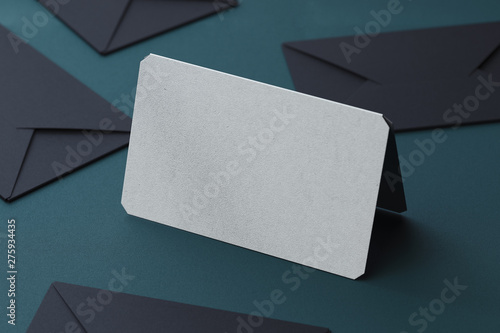 White blank business card and black envelopes on dark background. 3d rendering. © ekostsov