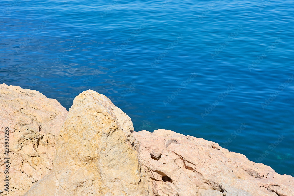 Stones on a sea coast of Colimbari, Crete, Greece against a blue sea water. Copy space. Stones on a sea coast of Colimbari, Crete, Greece against a blue sea water. Copy space.