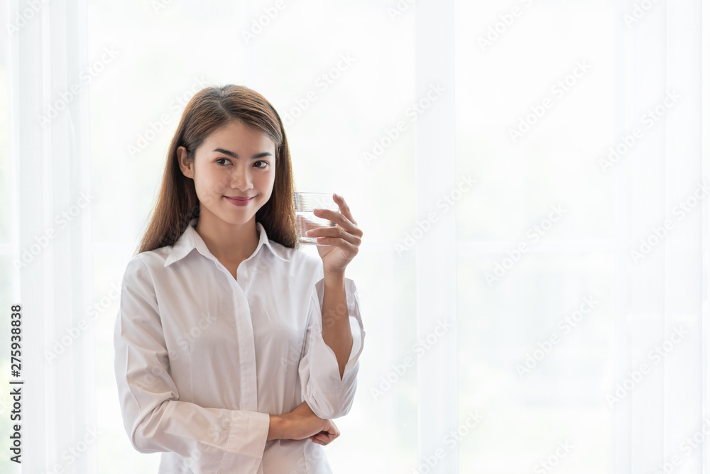 Young Asian woman holding glass of water Young Asian woman holding glass of water