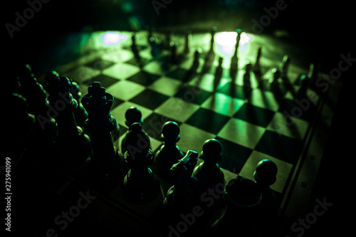 Chess board game concept of business ideas and competition. Chess figures on a dark background with smoke and fog.