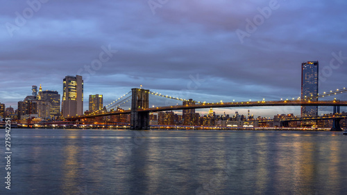 Panorama scene of Brooklyn Bridge beside the east river with New york Cityscape at the twilight time, USA downtown skyline, Architecture and building with tourist concept © THANANIT