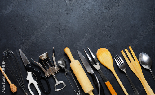Wooden and metal kitchen utensils. Tools for cooking. Dark background. Flat lay. Copy space