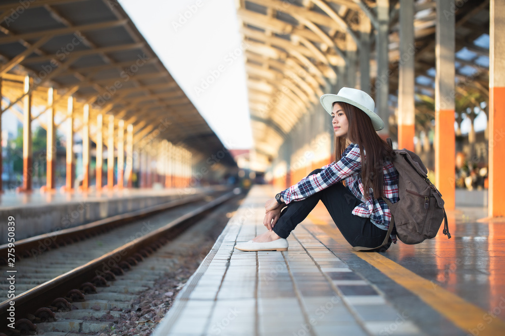 Obraz premium Active and travel lifestyle concept, Woman traveler tourist walking with luggage at train station.