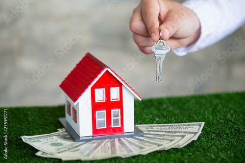 Your new house, real estate agent holding house key to his client after signing contract agreement in office,concept for real estate, renting property