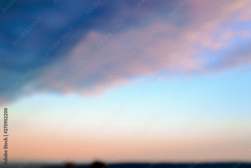 Blurred background of evening sky of pink and blue colors over a sea. Sunset sky pastel background.