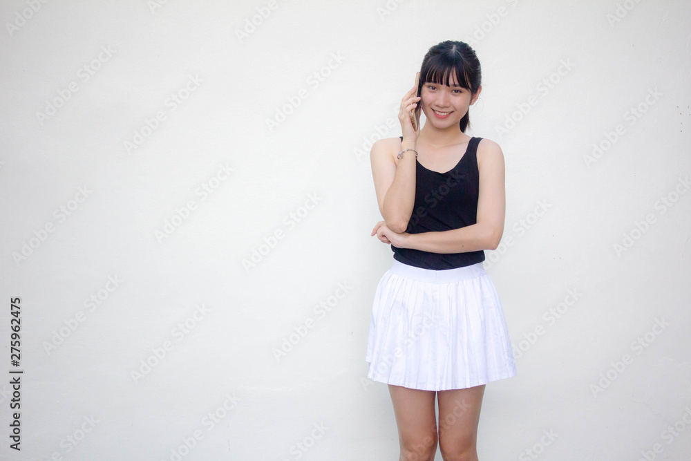 Portrait of thai adult beautiful girl black shirt white skirt calling smart phone Portrait of thai adult beautiful girl black shirt white skirt calling smart phone