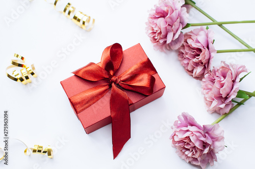 White background with red gift box and peony flowers  top view