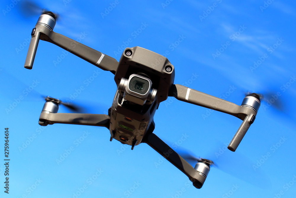Flight of the drone against the blue sky on a sunny day. View from the front. Flight of the drone against the blue sky on a sunny day. View from the front.