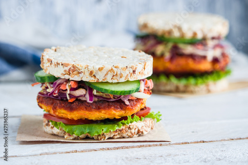healthy vegetarian burgers with rice crisp bread carrot cutlet lettuce coleslaw tomato cucumber on the table. healthy snack