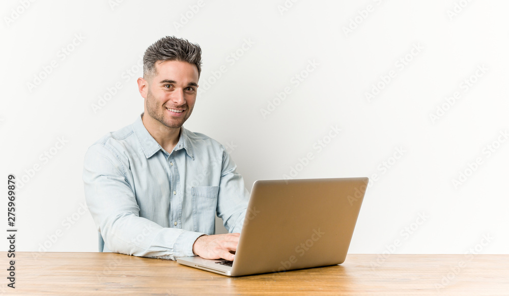 Young handsome man working with his laptop happy, smiling and cheerful. Young handsome man working with his laptop happy, smiling and cheerful.