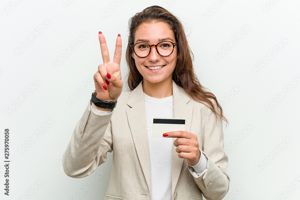Young european business woman holding a credit card showing number two with fingers. Young european business woman holding a credit card showing number two with fingers.