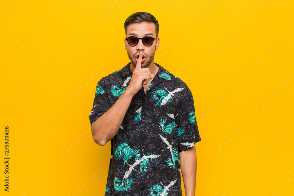 Young filipino man wearing summer clothes keeping a secret or asking for silence. Young filipino man wearing summer clothes keeping a secret or asking for silence.