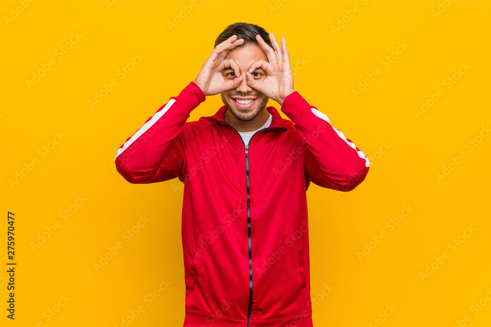Young filipino fitness man showing okay sign over eyes Young filipino fitness man showing okay sign over eyes
