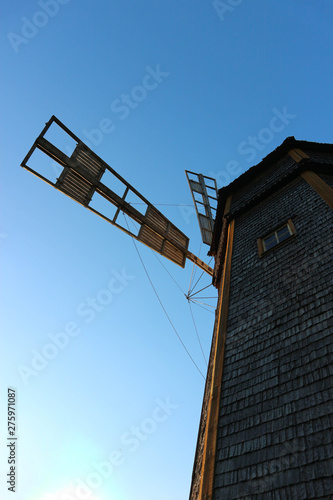 Old wooden windmill with blue sky on the background view from below