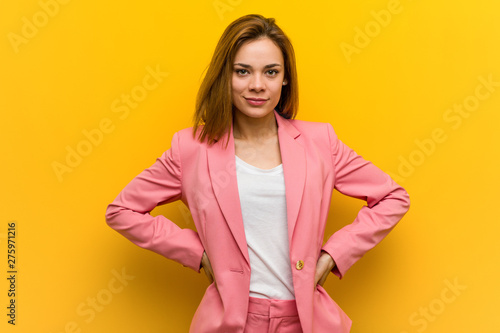 Young fashion business woman confident keeping hands on her hips.