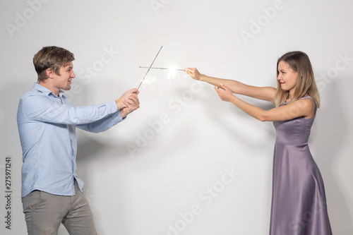 Celebration, party and holiday concept - Portrait of young couple fooling around with sparklers