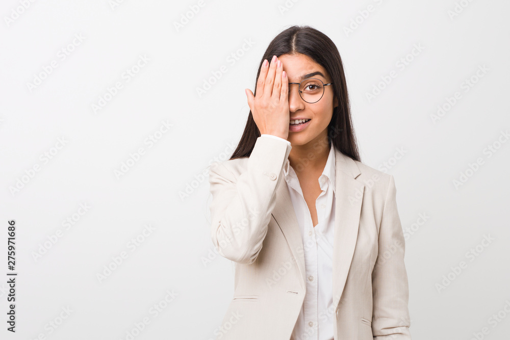 Young business arab woman isolated against a white background having fun covering half of face with palm. Young business arab woman isolated against a white background having fun covering half of face with palm.