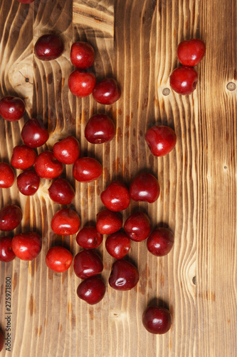 Red sweet cherry scattered on a wooden table