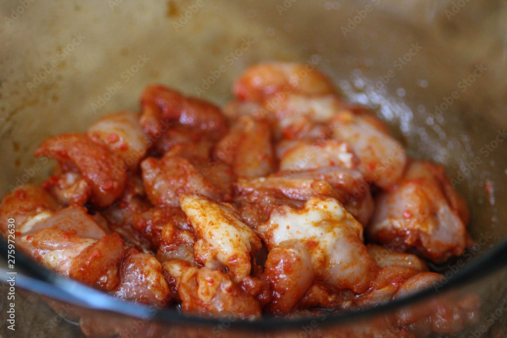 marinated chicken indian tandoori seasoning in a bowl, on wooden background, in the kitchen marinated chicken indian tandoori seasoning in a bowl, on wooden background, in the kitchen