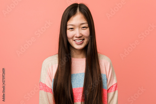 Fotografie Young cool chinese woman laughs and closes eyes, feels relaxed and happy