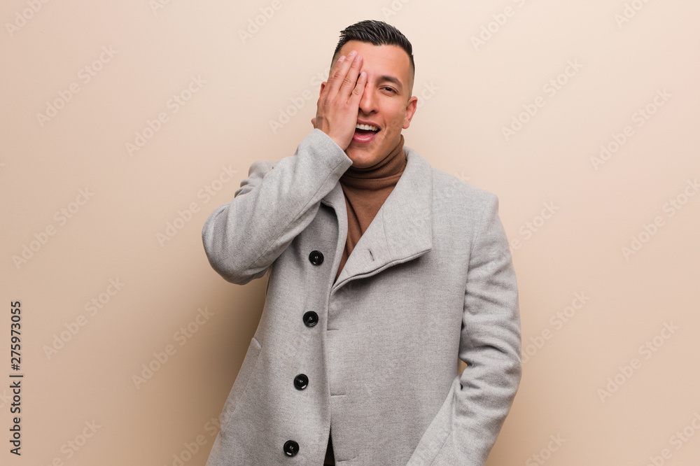 Young latin business man shouting happy and covering face with hand Young latin business man shouting happy and covering face with hand