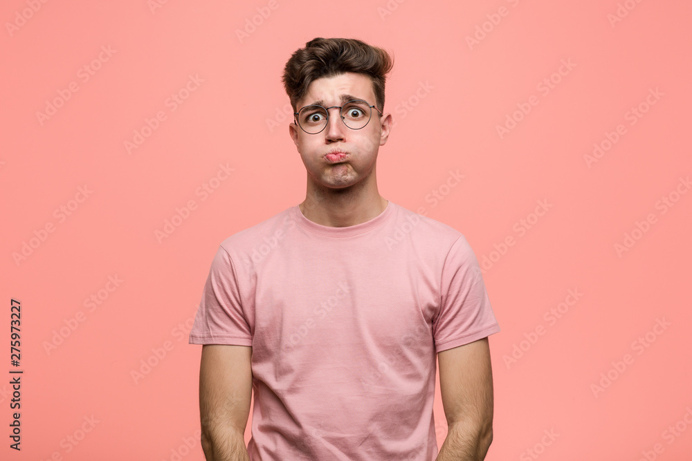 Young cool caucasian man blows cheeks, has tired expression. Facial expression concept. Young cool caucasian man blows cheeks, has tired expression. Facial expression concept.