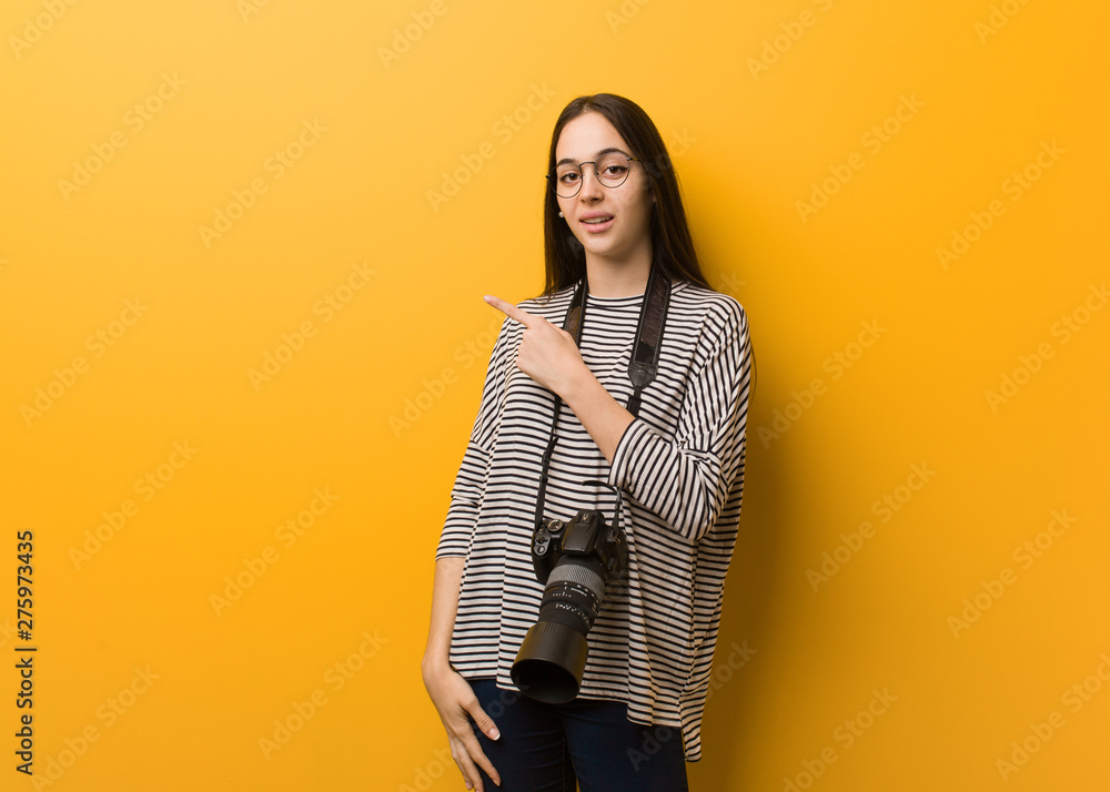 Young photographer woman smiling and pointing to the side Young photographer woman smiling and pointing to the side