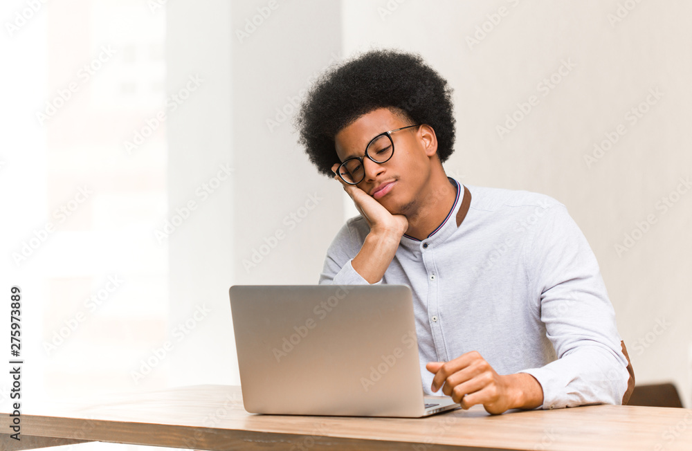 Young black man using his laptop tired and very sleepy Young black man using his laptop tired and very sleepy