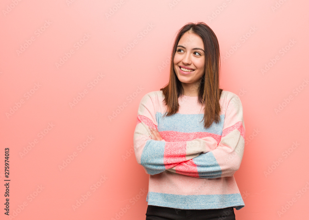 Young cute woman smiling confident and crossing arms, looking up Young cute woman smiling confident and crossing arms, looking up
