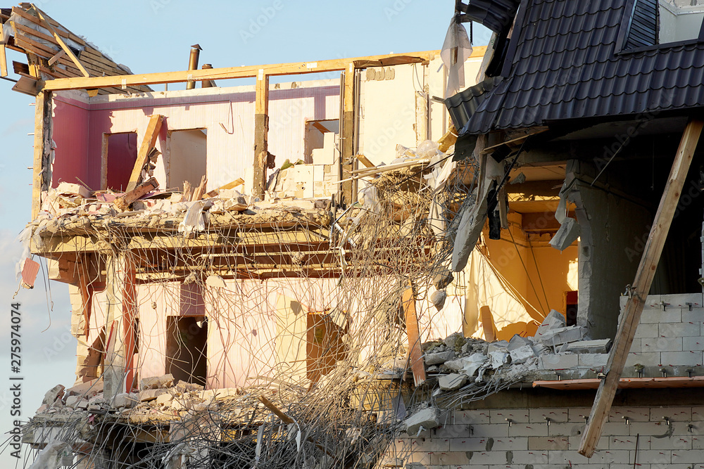 The destruction of a multi-storey building close-up. Floors and walls spread, reinforcement sticking out, wooden partitions. The roof of the building is broken. The destruction of a multi-storey building close-up. Floors and walls spread, reinforcement sticking out, wooden partitions. The roof of the building is broken.