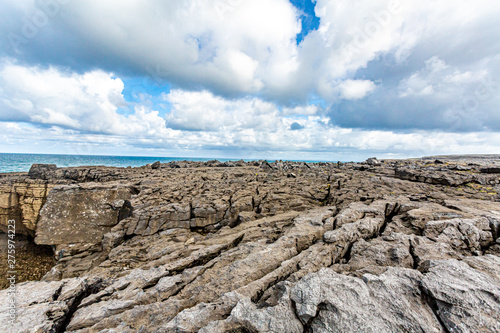 Spectacular limestone landscape with sea the sea in the background at Bothar nA hAillite, Geopark geosites, Wild Atlantic Way, beautiful spring day in County Clare in Ireland photo