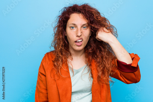 Young redhead elegant woman showing a disappointment gesture with forefinger.