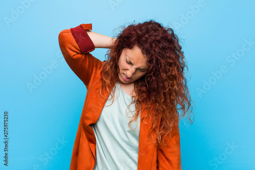 Young redhead elegant woman suffering neck pain due to sedentary lifestyle.