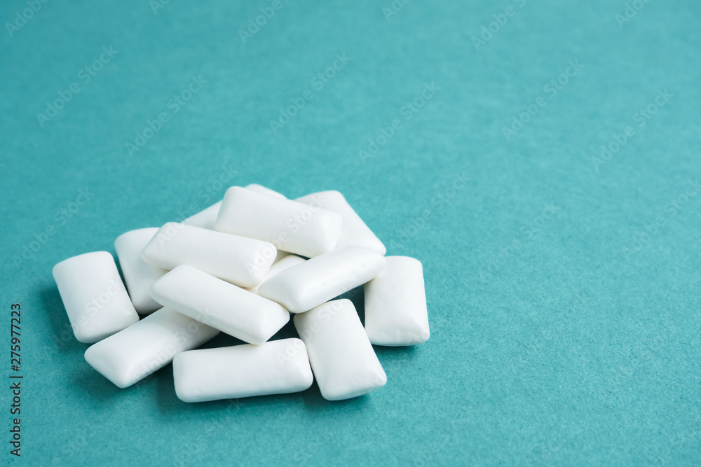 heap of chewing gums on blue background, copy space