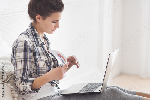 Young attractive woman working at home at the laptop photo