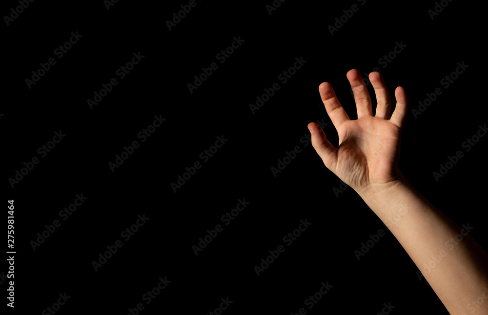 Fototapeta premium The hand of a young man on a black background